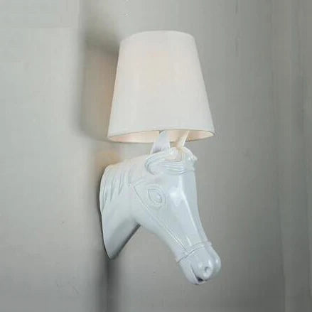 Wall-mounted lamp shaped like a horse head with a white shade on a gray wall. @ ghoddosh.com