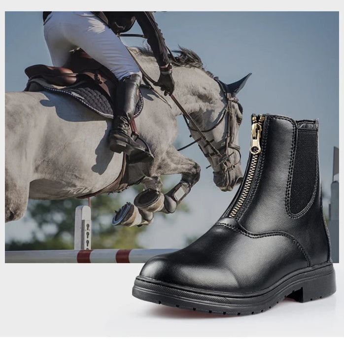 Black leather boot with a zipper on a gray surface . Ghoddosh