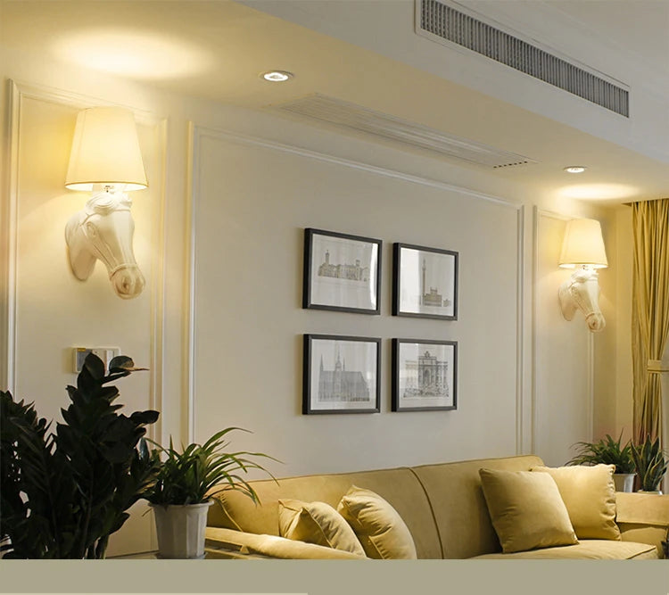 Living room with beige sofa, framed pictures on the wall, and decorative elements. @ ghoddosh.com