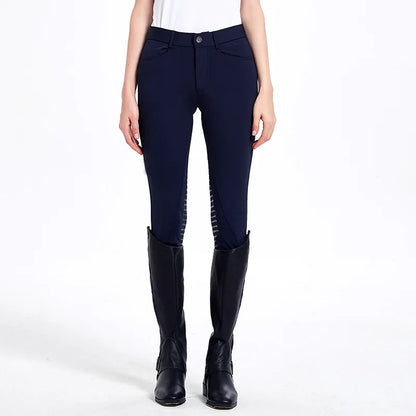 Person wearing navy riding pants with black knee patches and black riding boots on a white background .Ghoddosh 