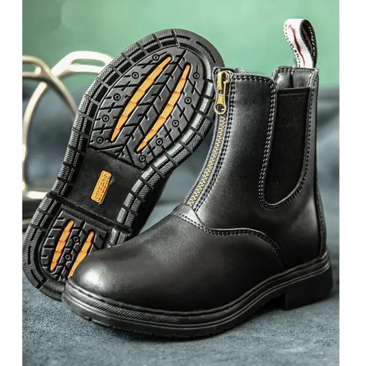 Black leather boot with a zipper on a gray surface . Ghoddosh